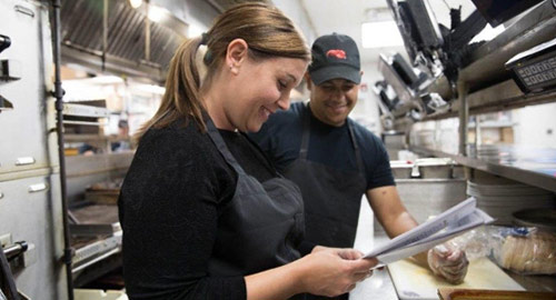 Two Red Lobster employees review an inventory list in the kitchen.